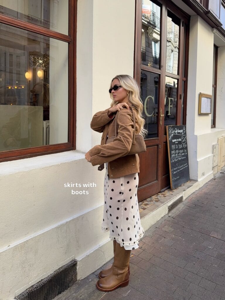 may outfit with tan suede jacket, white and black polka dot midi skirt, and cognac knee-high boots, text "skirts with boots"
