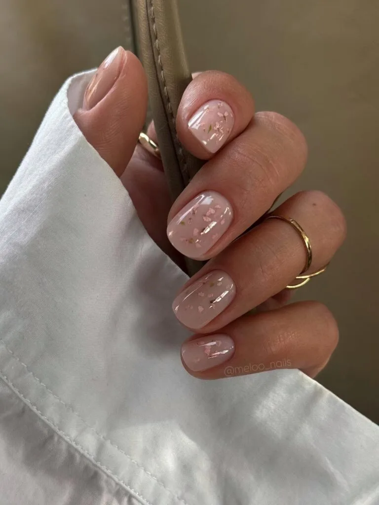 may nails, short round nude pink nails with dried pressed flower and cherry blossom flecks in gloss
