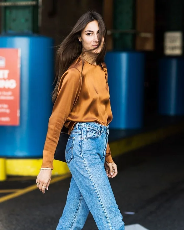 spring fashion trends 2026, copper silk blouse tucked into light-wash jeans