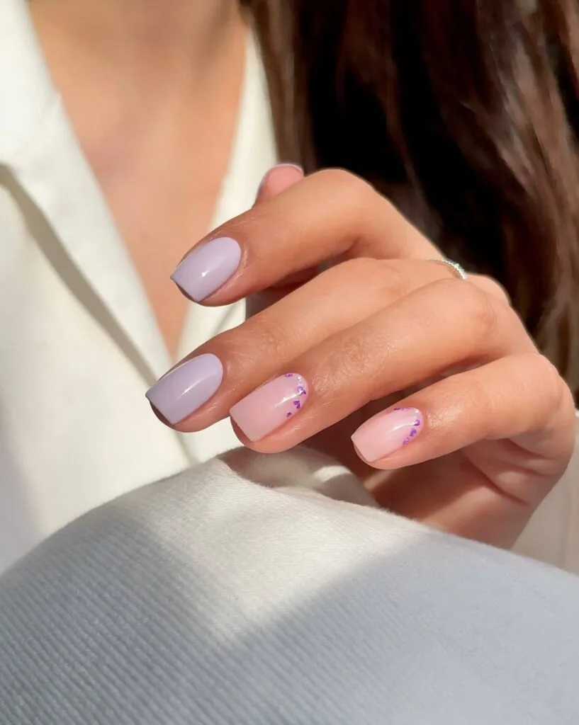 simple spring nails, short square lavender and sheer pink nails with tiny purple heart glitter accents
