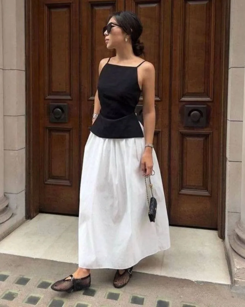 spring fashion trends 2026, black woven mesh ballet flats with black peplum top and white midi skirt