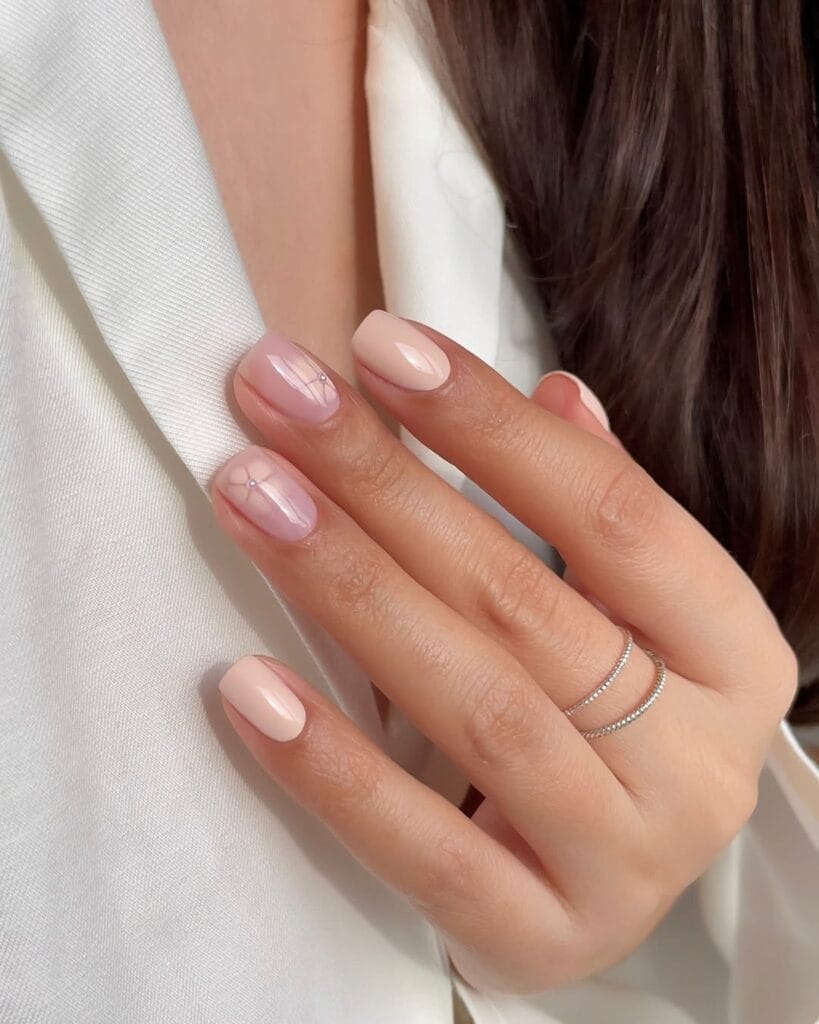 simple spring nails, short square sheer pink nails with subtle hand-drawn flower and rhinestone accents