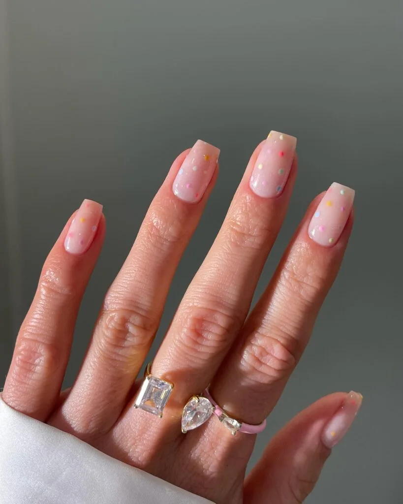 may nails, short square sheer pink nails with multicolored pastel confetti dot accents
