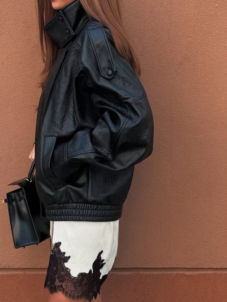 spring fashion trends 2026, white satin skirt with black lace trim under black leather jacket