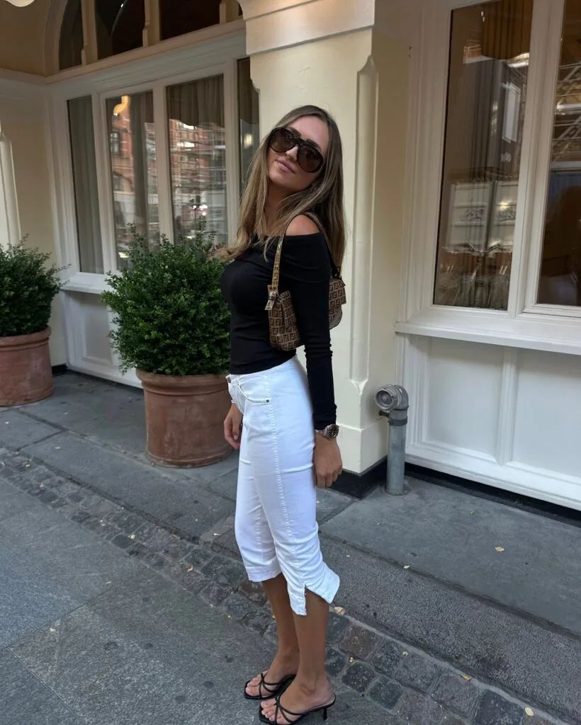 spring fashion trends 2026, white capri pants with black off-shoulder top and heeled sandals
