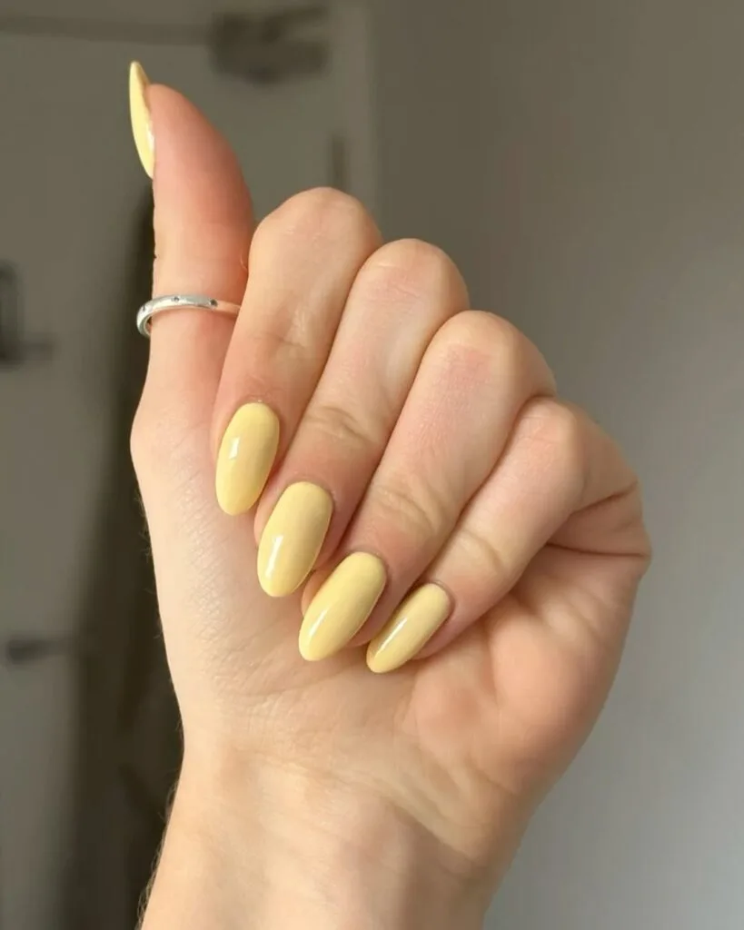 june nail color trends, glossy butter yellow almond nails with solid finish