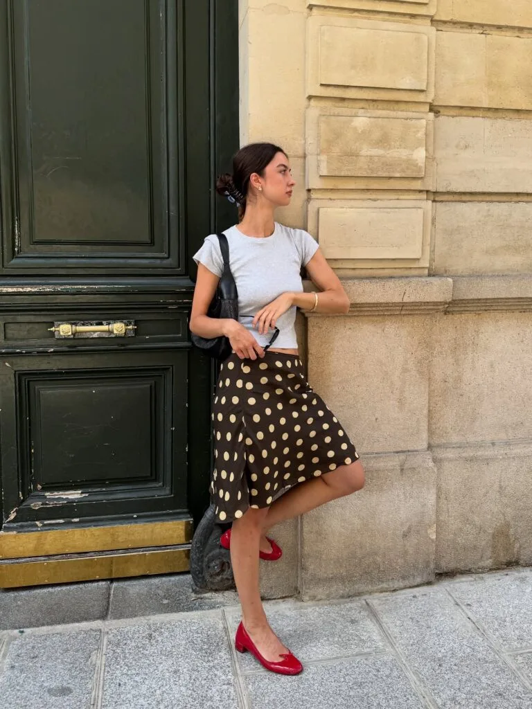 summer fashion trends 2026, chocolate and cream polka dot skirt with grey crop tee and red flats