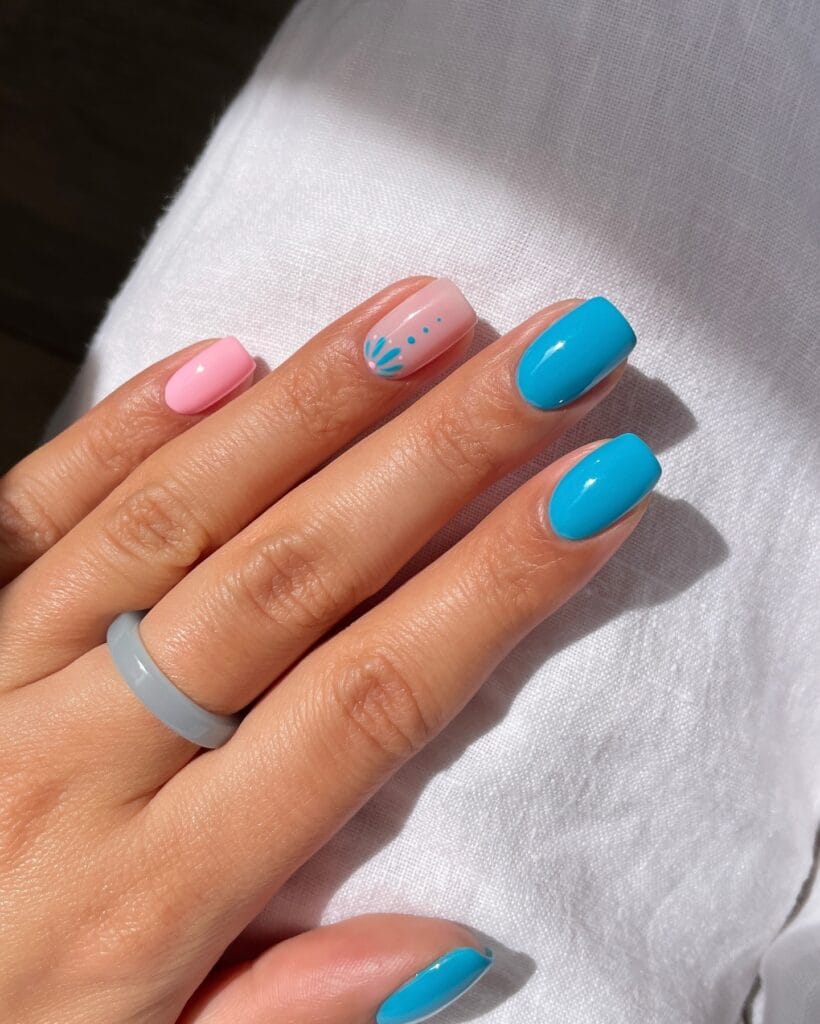 July nail ideas, short square pink and sky blue nails with sheer accent nail and tiny blue flower and dot art
