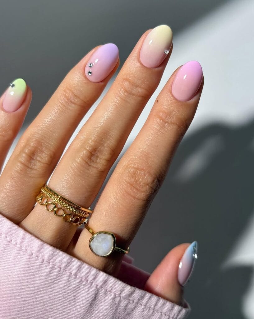  June nail ideas, pastel multicolor ombre almond nails with pink lavender green and blue tips and rhinestone accents
