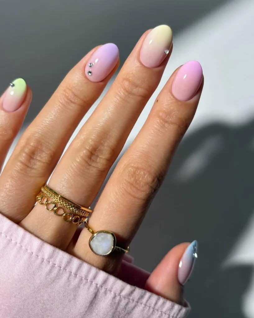  June nail ideas, pastel multicolor ombre almond nails with pink lavender green and blue tips and rhinestone accents
