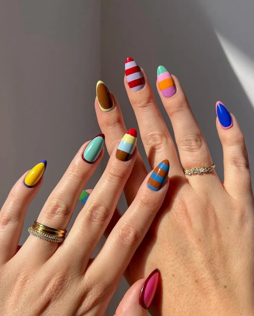 summer nail trends 2026, bold 70s color-blocked almond nails in orange blue red mint and yellow