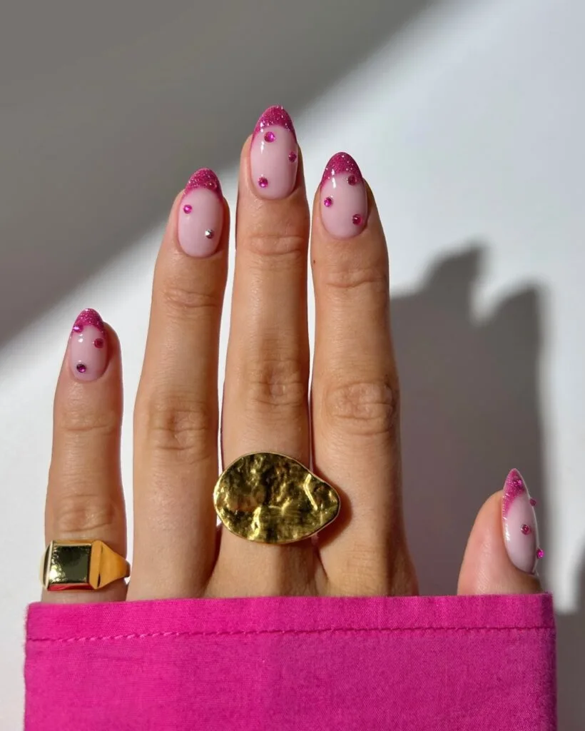 summer nail trends 2026, pink almond nails with glitter French tips and hot pink gem accents