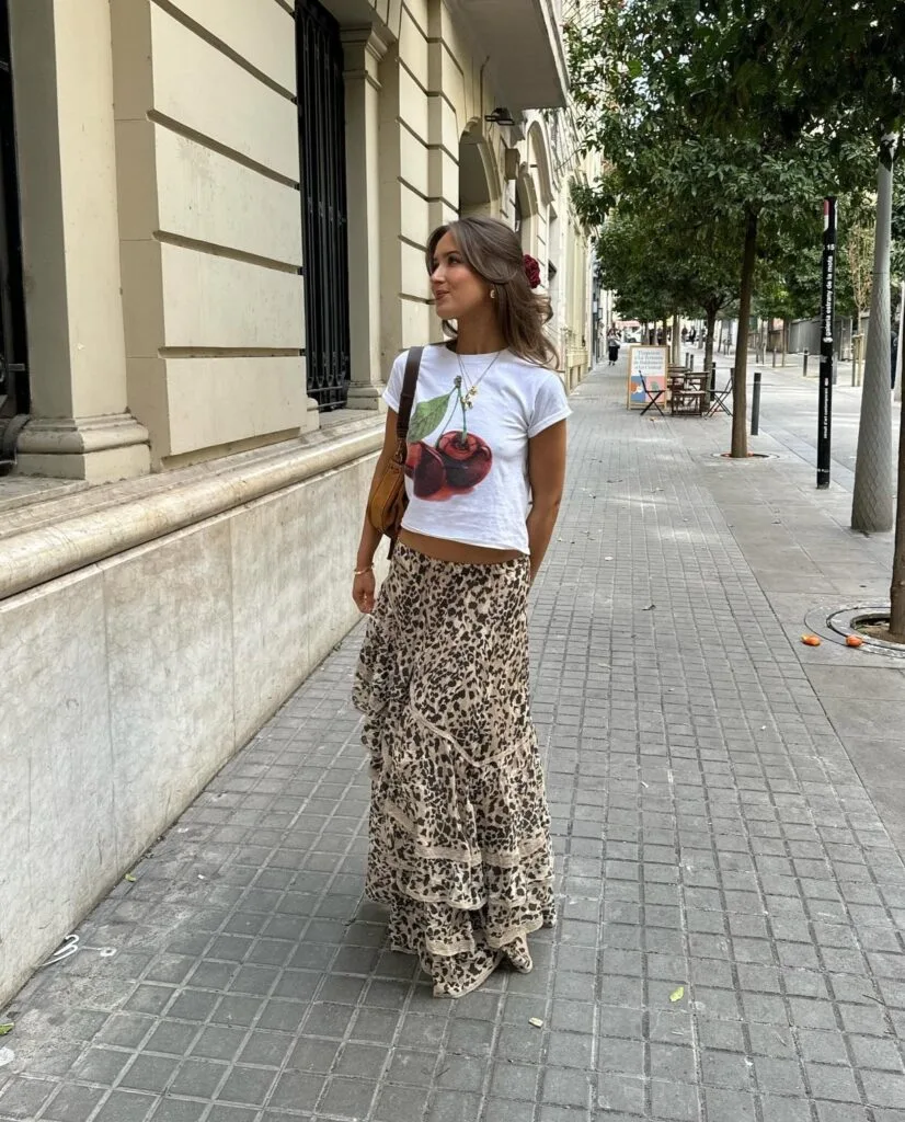 june outfit with white cherry graphic tee, leopard print tiered maxi skirt, and brown shoulder bag