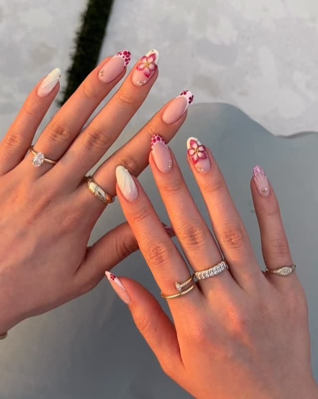 June nail ideas, sheer almond nails with red floral art French tips dotted petals and rhinestone accents
