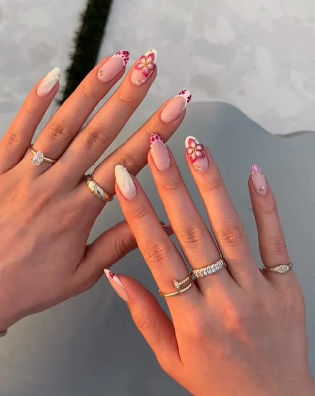 June nail ideas, sheer almond nails with red floral art French tips dotted petals and rhinestone accents
