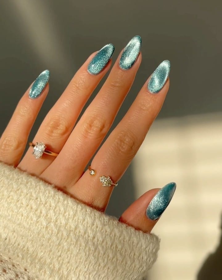 june nail color trends, deep teal cat eye almond nails with velvet shimmer finish
