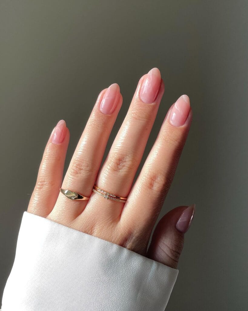 neutral summer nails, almond milky pink nails with soft marble swirl pattern and glazed pearlescent finish
