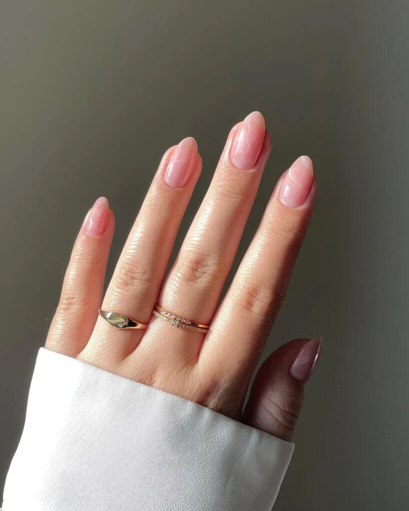 neutral summer nails, almond milky pink nails with soft marble swirl pattern and glazed pearlescent finish
