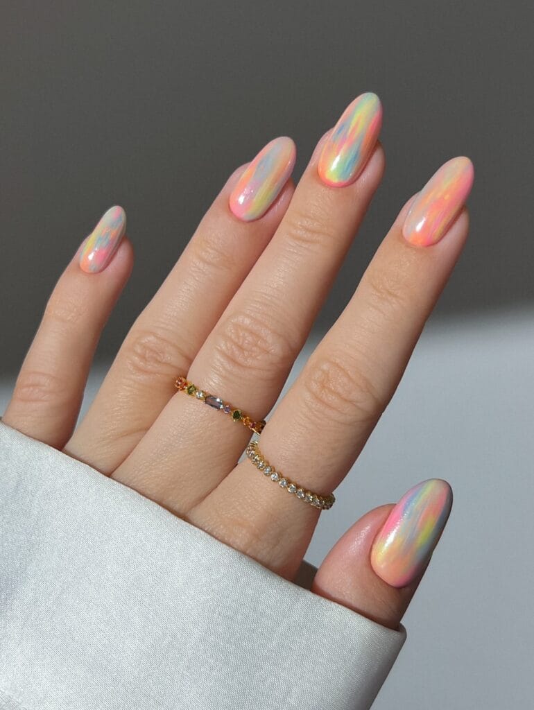 July nail ideas, pastel rainbow watercolor almond nails with pearly opal chrome glaze finish
