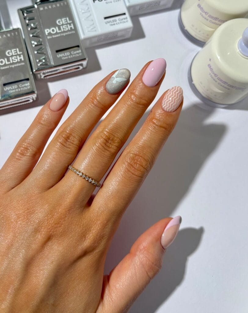 July nail ideas, soft neutral oval nails with nude pink silver butterfly white squiggle and French tips
