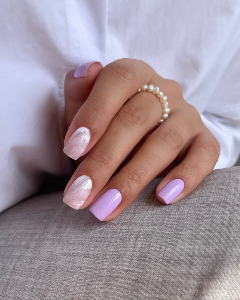 June nail ideas, lilac glossy short square nails with white marble swirl accent nails and glitter speckles
