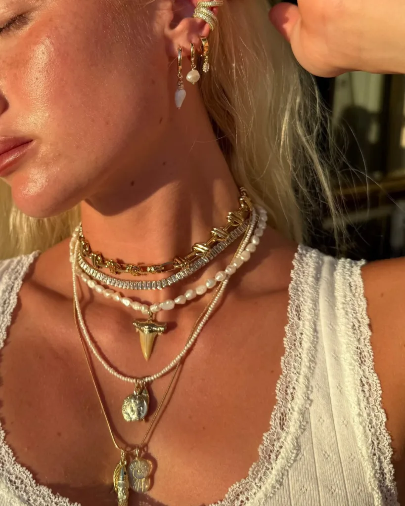 summer fashion trends 2026, layered gold and pearl necklaces with shark tooth and coin pendants