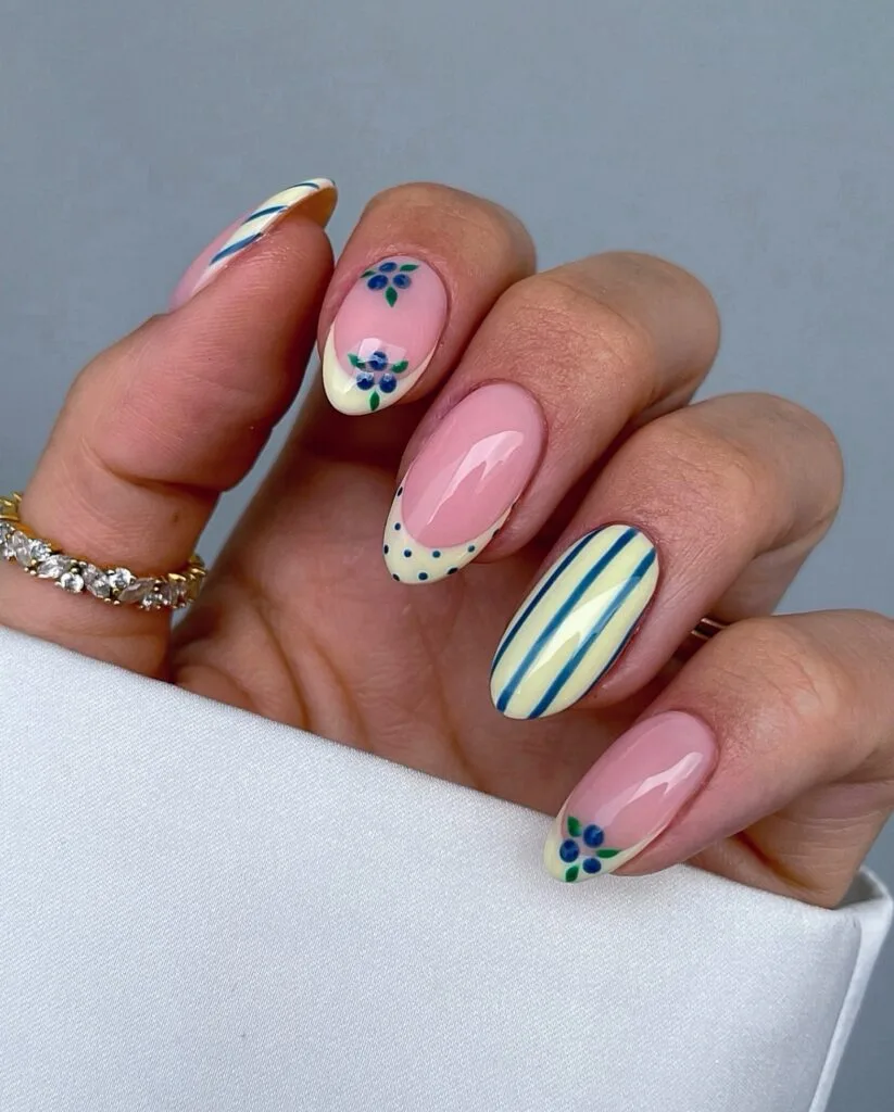 june nail color trends, blueberry art on pink base with butter yellow striped accent nails