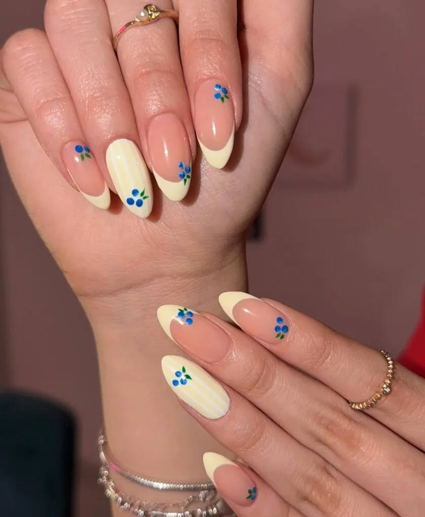 june nail color trends, butter yellow French tip almond nails with blueberry cluster accents