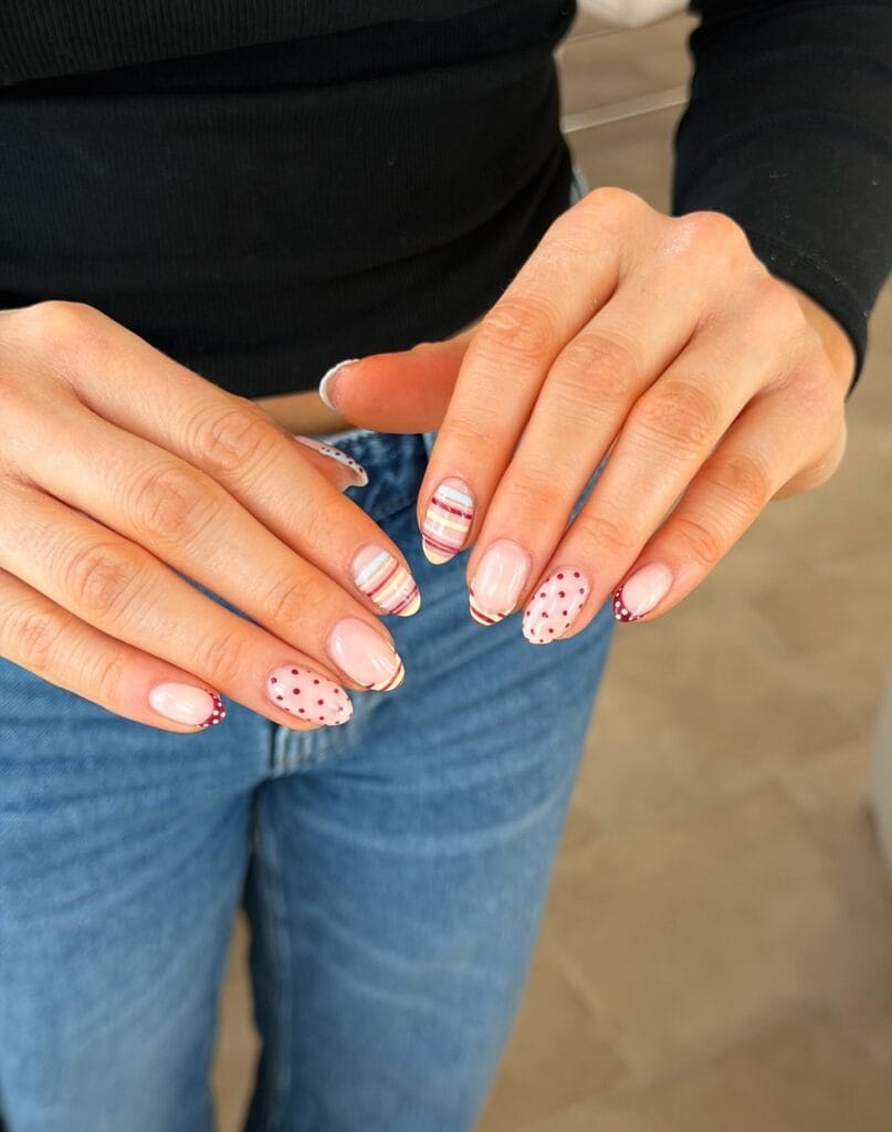 June nail ideas, mix and match almond nails with retro stripes and red polka dots on nude base
