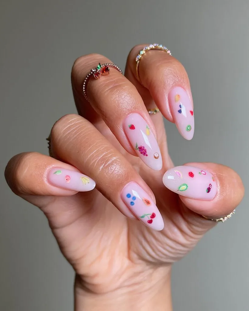 summer nail trends 2026, milky pink almond nails with tiny scattered fruit art cherries blueberries lemons