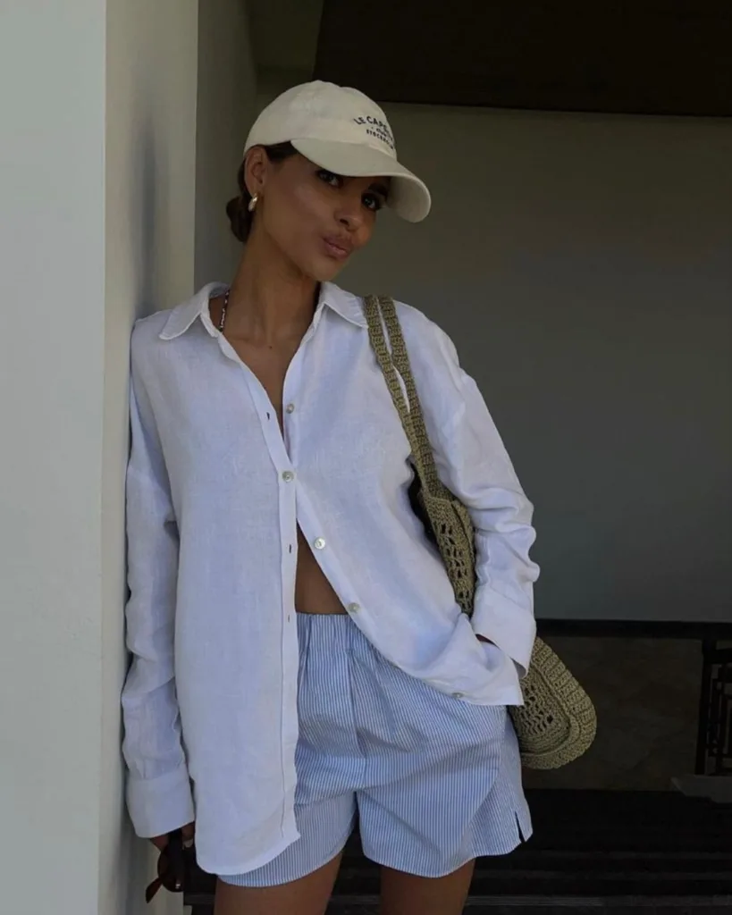 summer fashion trends 2026, blue striped boxer shorts with white linen button-down and baseball cap