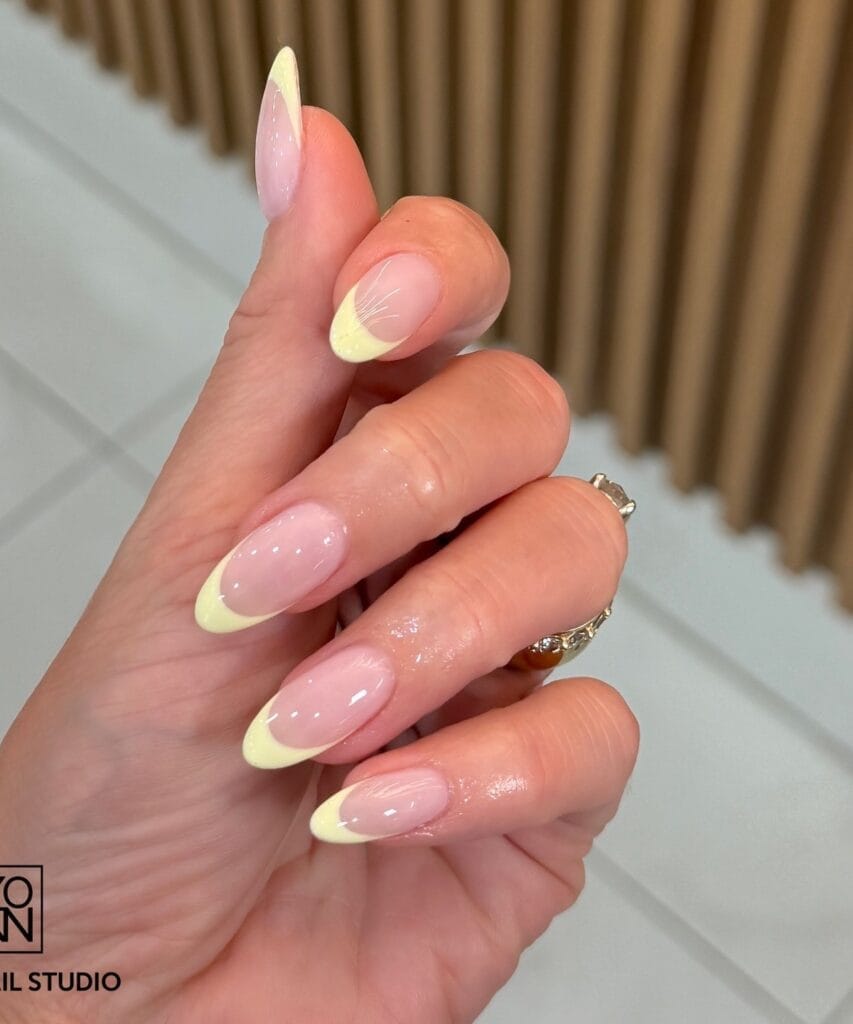 june nail color trends, lemon yellow French tip almond nails with sheer pink base