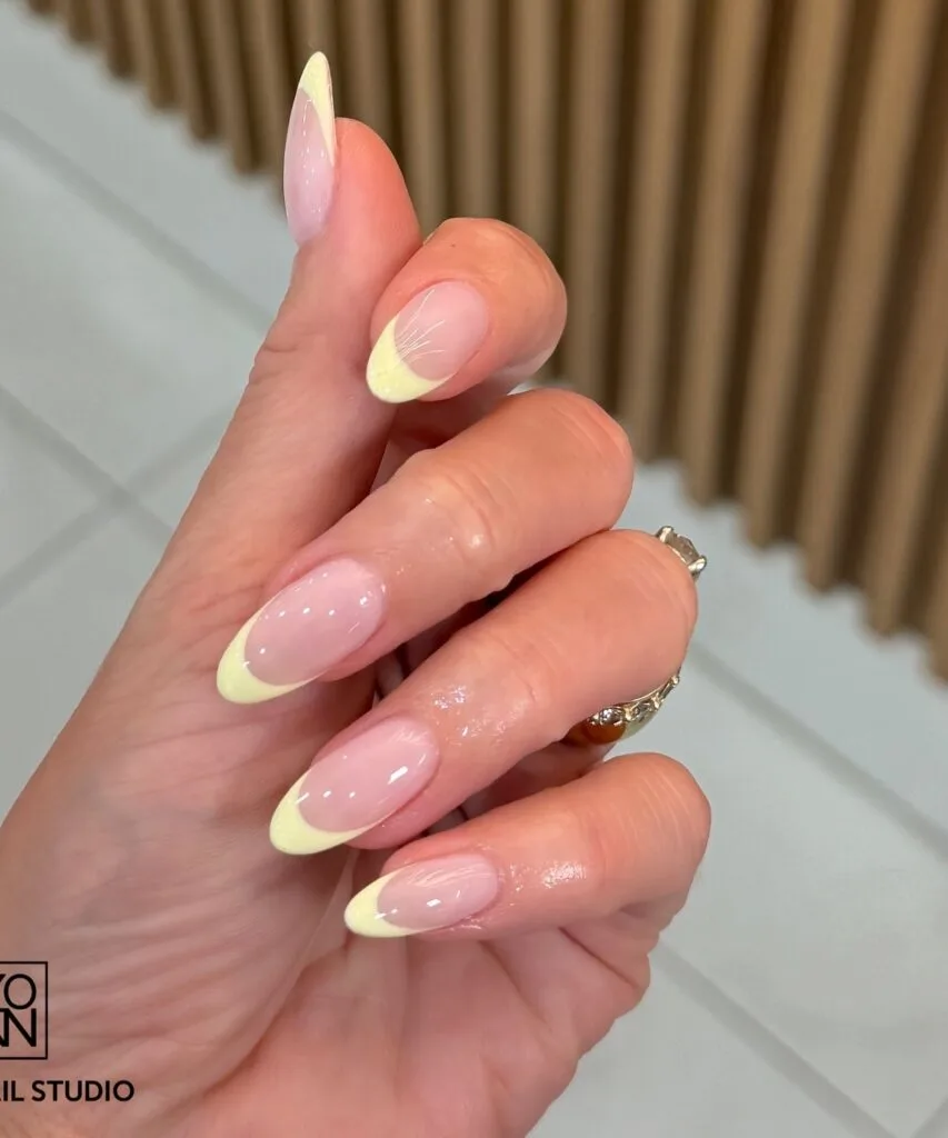 june nail color trends, lemon yellow French tip almond nails with sheer pink base