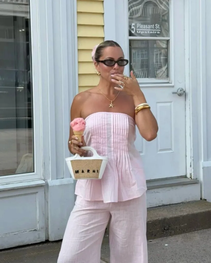 summer fashion trends 2026, pink linen strapless pleated top and matching wide-leg pants with straw bag