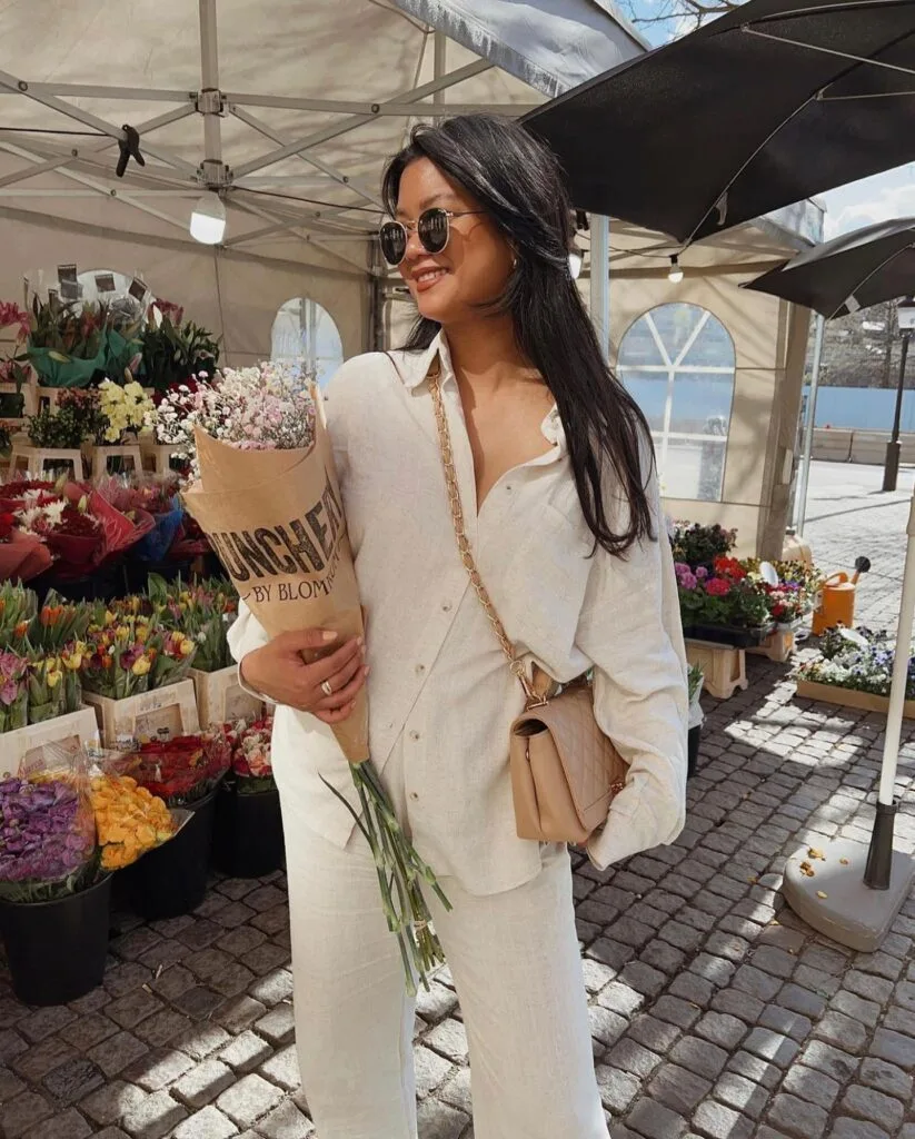 summer fashion trends 2026, cream linen button-down shirt and matching wide-leg trousers with quilted crossbody bag