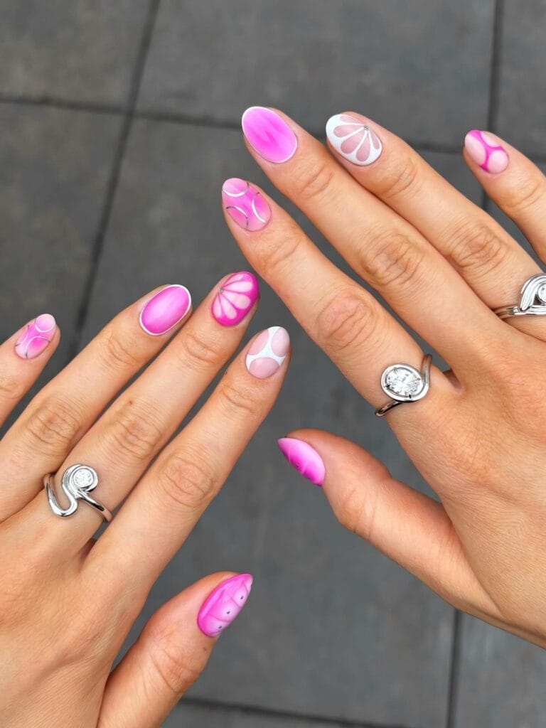 June nail ideas, hot pink almond nails with white abstract retro flower art
