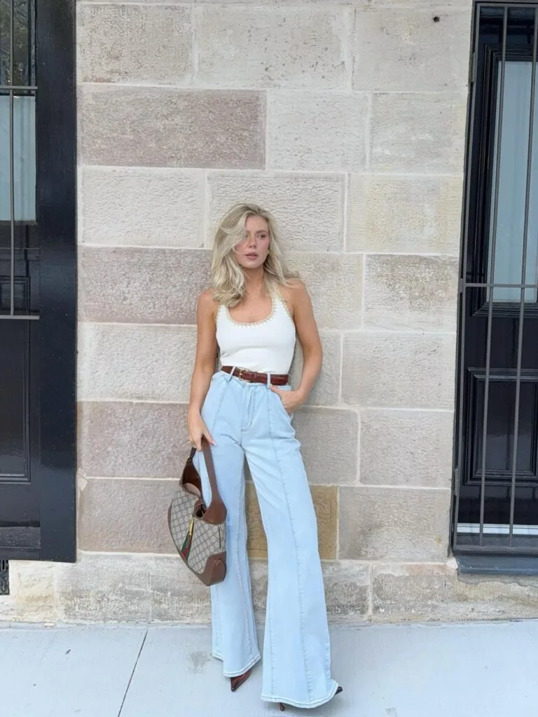 summer outfit with white scoop tank, light wash high-waist flare jeans, brown leather belt, and brown bag
