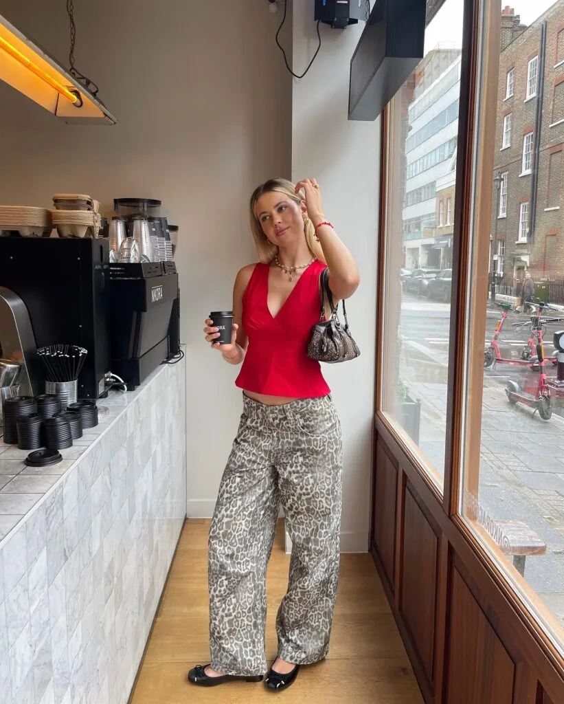 summer outfit with red peplum top, leopard print wide-leg pants, black ballet flats, and leopard bag
