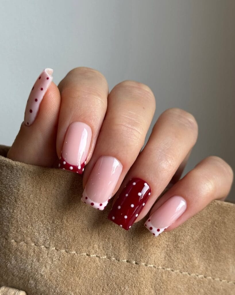 summer nail colors, deep cherry polka dot French tips on nude base with cherry accent