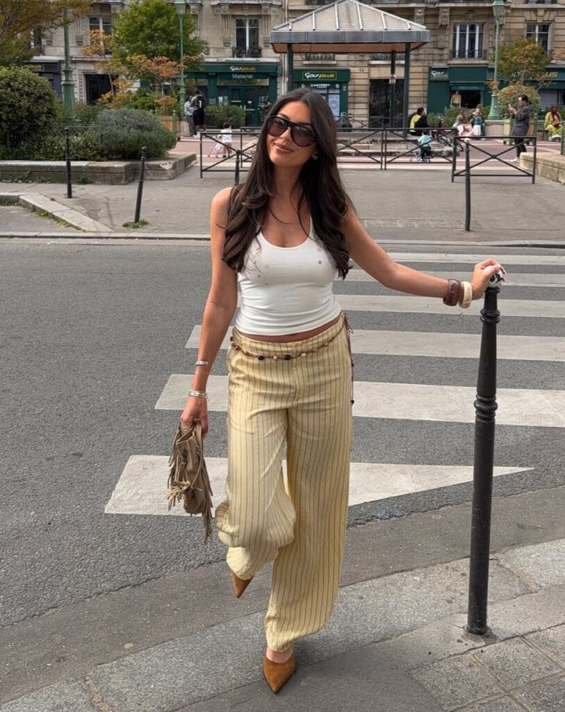 summer outfit with white tank, butter yellow pinstripe trousers, beaded belt, and brown suede heels
