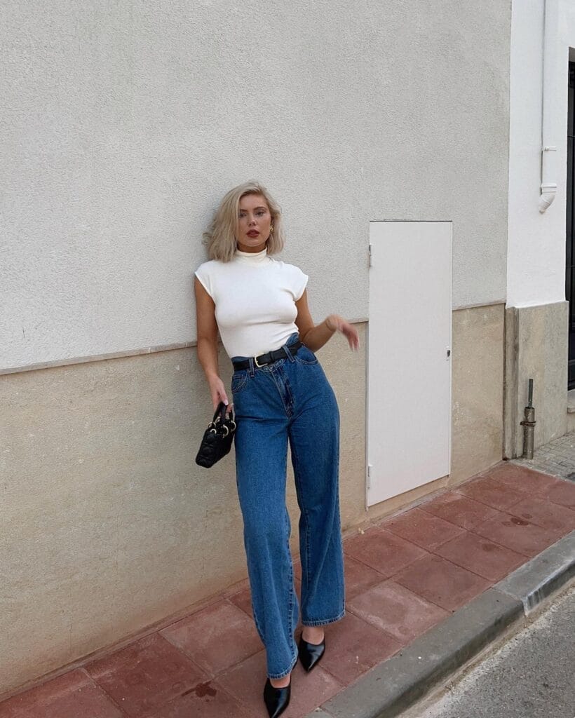  July outfit with white mock-neck top, belted high-waist wide-leg jeans, and pointed black mules

