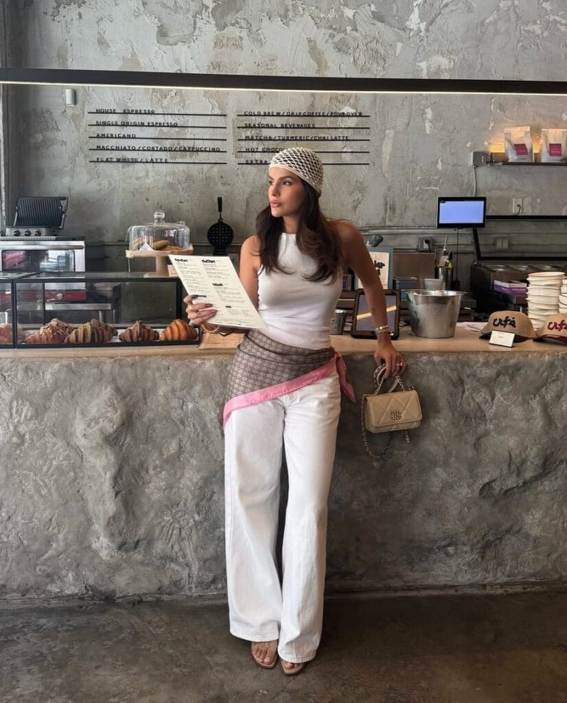 summer outfit with white tank, white wide-leg jeans, printed silk hip scarf, and crochet headscarf
