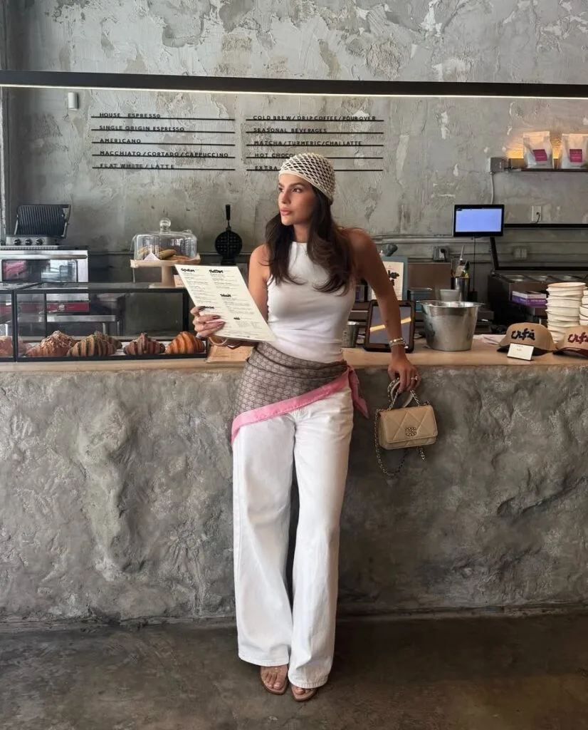 summer outfit with white tank, white wide-leg jeans, printed silk hip scarf, and crochet headscarf
