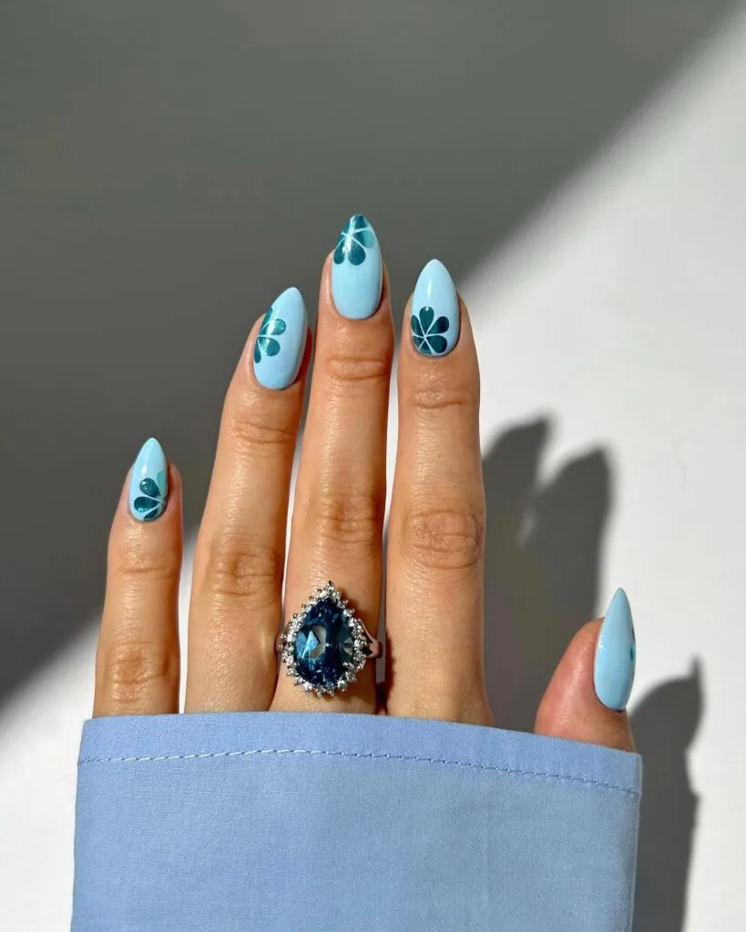 july nail colors, baby blue almond nails with dark teal petal flower art