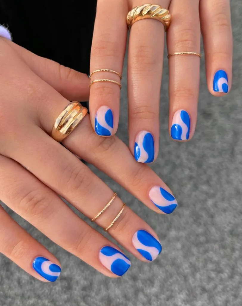 summer nail colors, short squoval nails with cobalt blue abstract swirls on sheer nude base