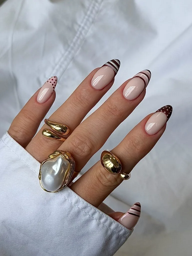 summer nails, almond nude nails with chocolate brown striped, dotted, and freckled French tips