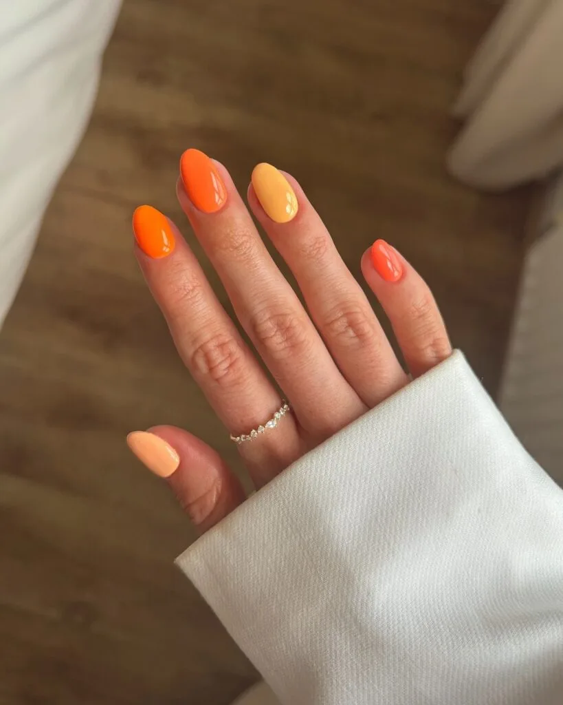august nail colors 2026, round nails in mixed orange shades from tangerine to peach
