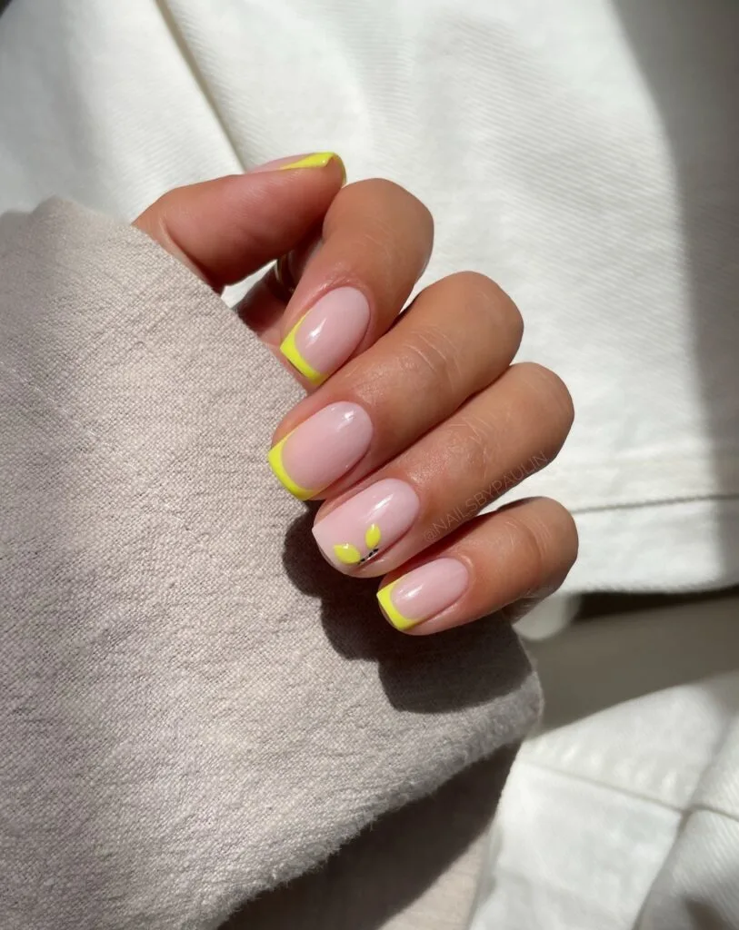 august nails, short square neon yellow micro French tips with tiny lemon leaf accent on sheer pink base
