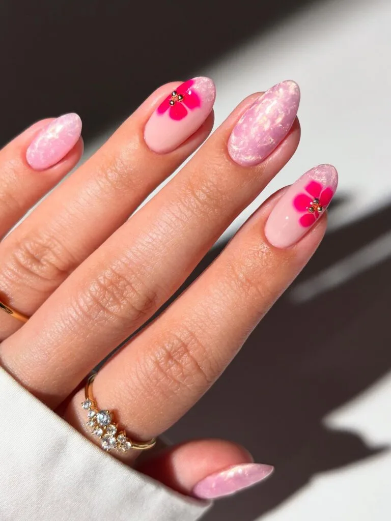 august nails, almond pink glitter marble nails with hot pink flower accents and gold bead centers
