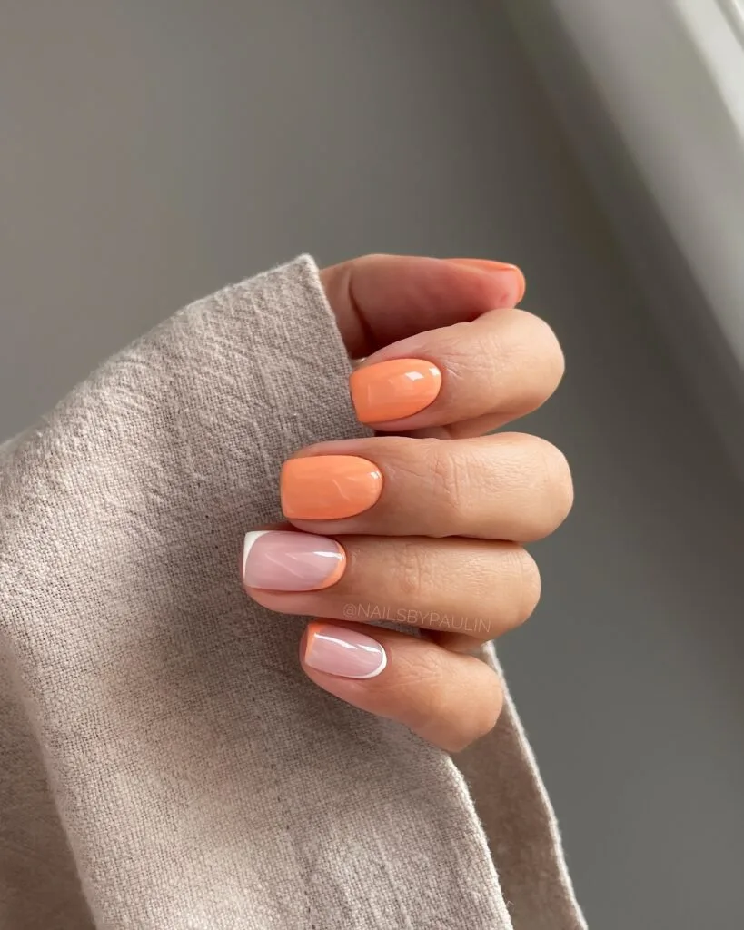 Short square September nails in golden apricot and milky pink with white curved tips